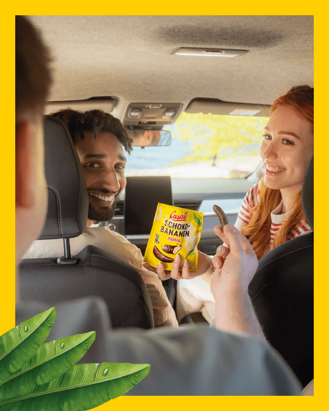 Junge Leute sitzen im Auto und teilen sich eine Packung Schoko-Bananen Minis