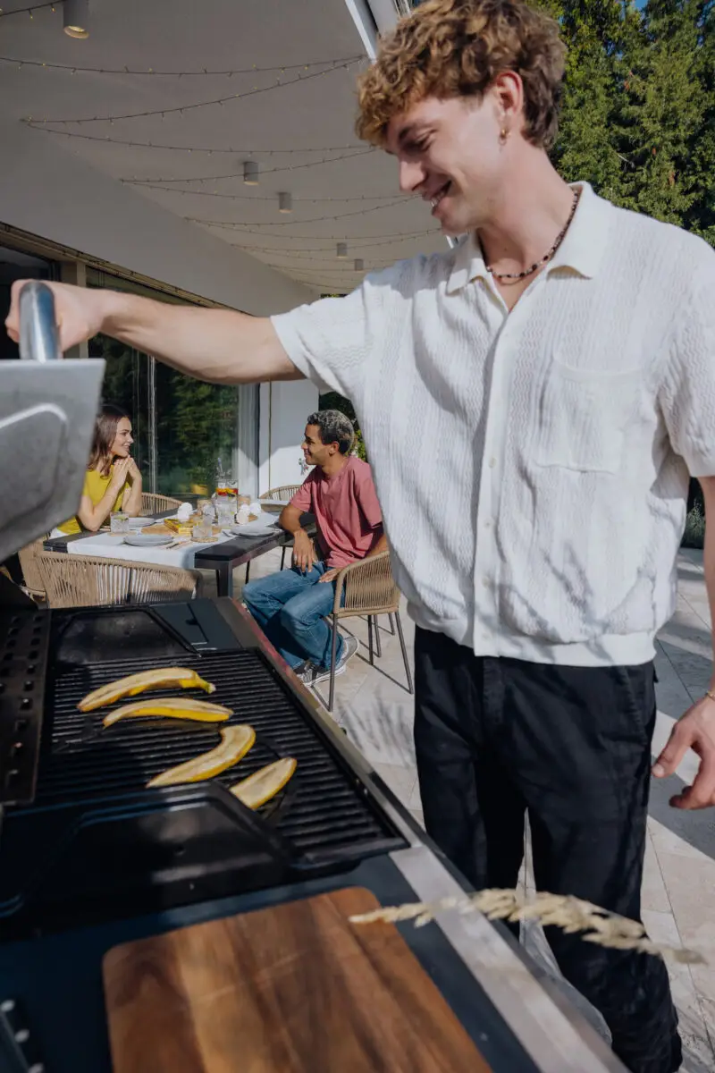 ein Mann grillt Bananen